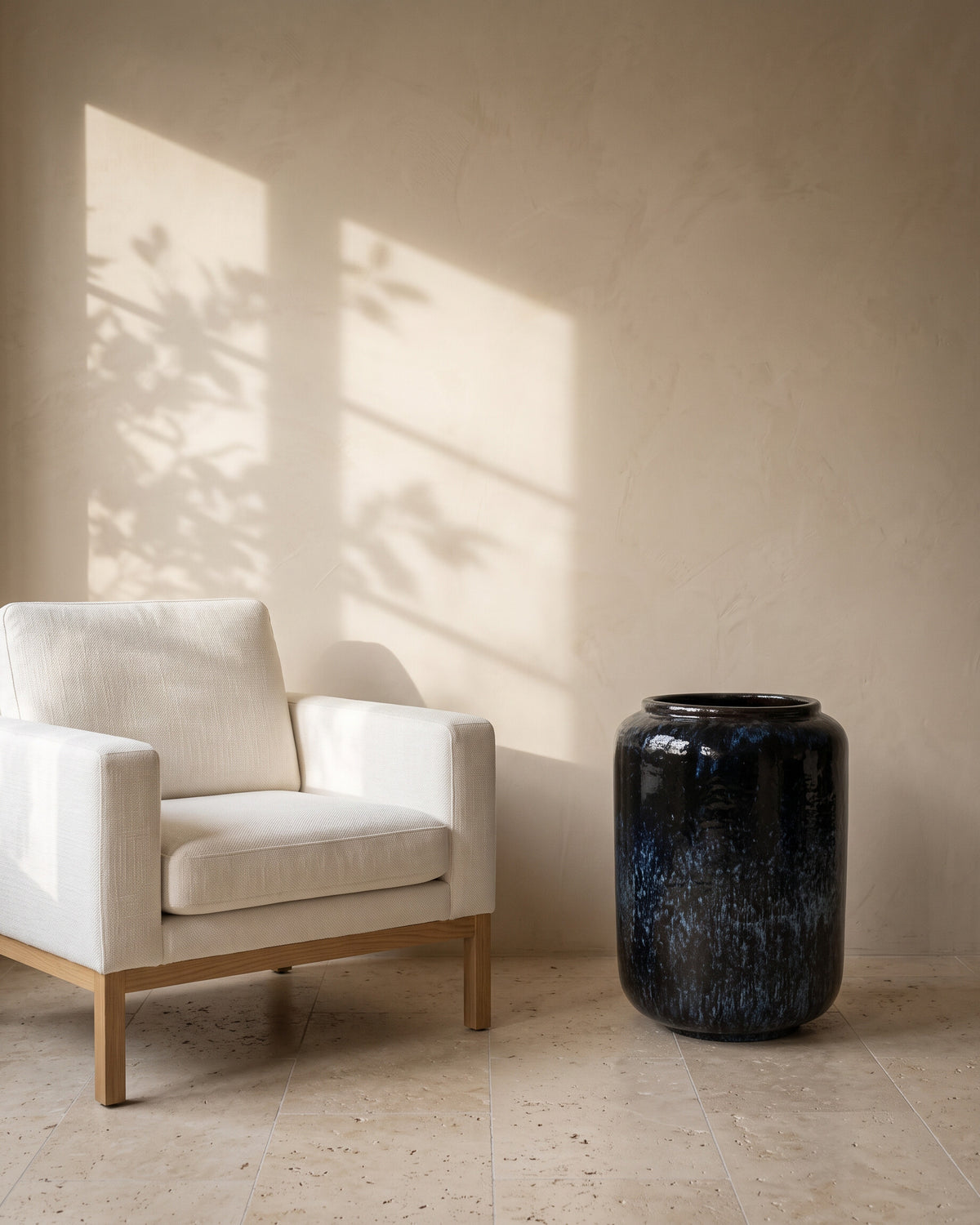 Deep Ocean Cylindrical Pot, shown beside a linen armchair for scale