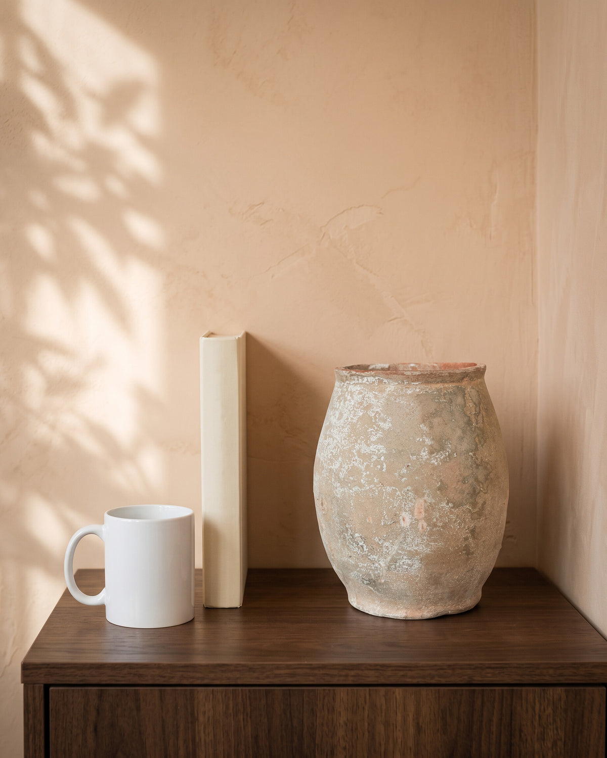 Vintage White Vase, shown on a walnut sideboard next to a coffee mug and a book for scale