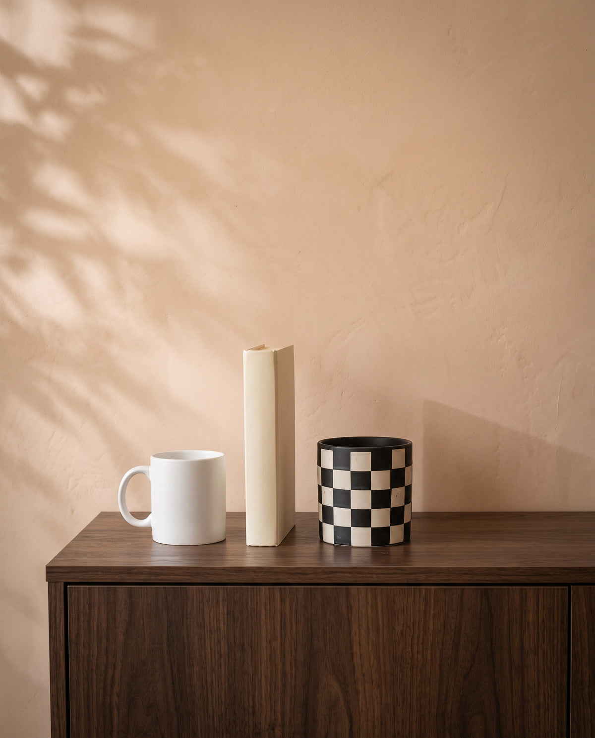 Chess Grid Pot, shown on a walnut sideboard next to a coffee mug and a book for scale