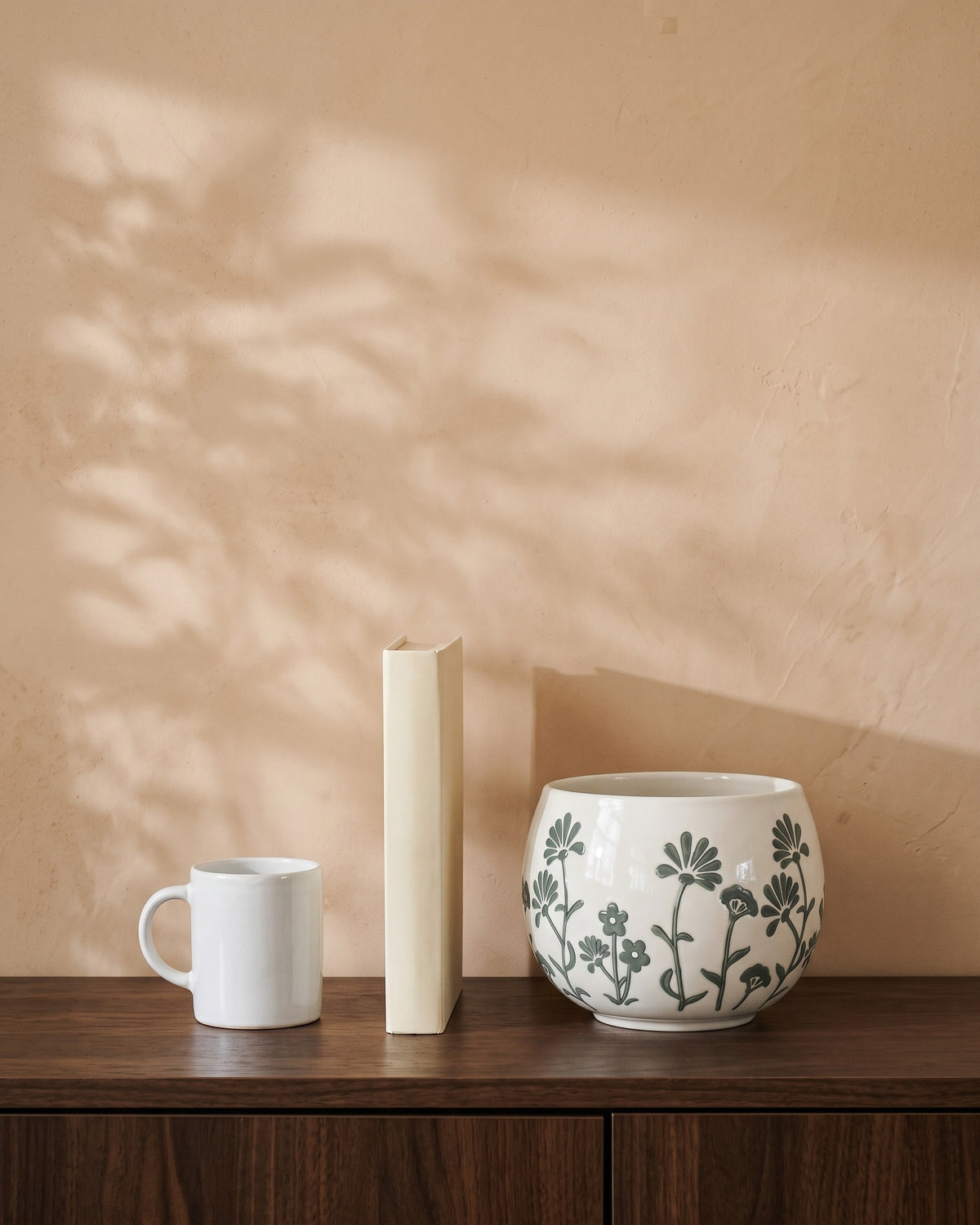 Green Floral Pot, shown on a walnut sideboard next to a coffee mug and a book for scale