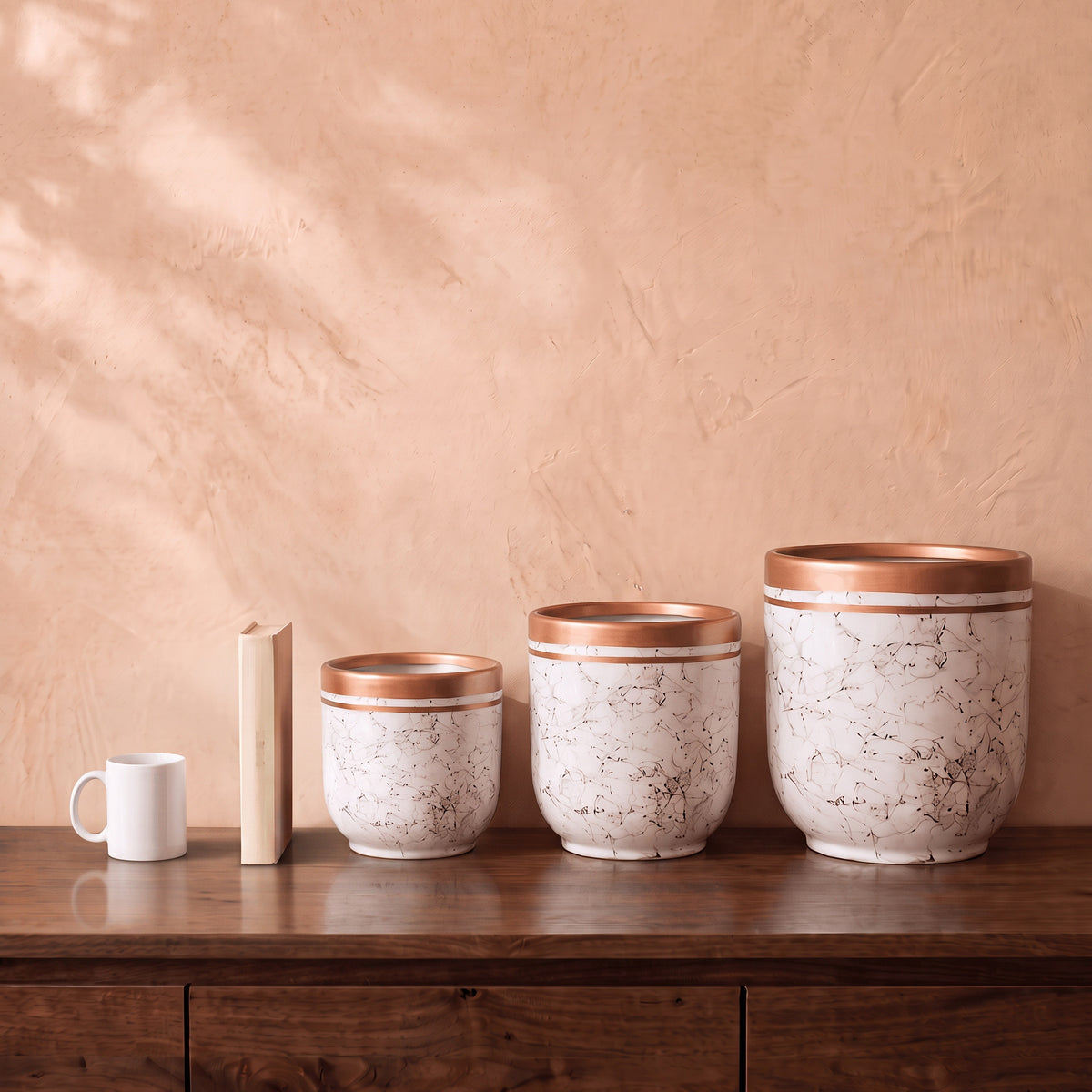 Marble Pot in white, all sizes, shown on a walnut sideboard next to a coffee mug and a book for scale