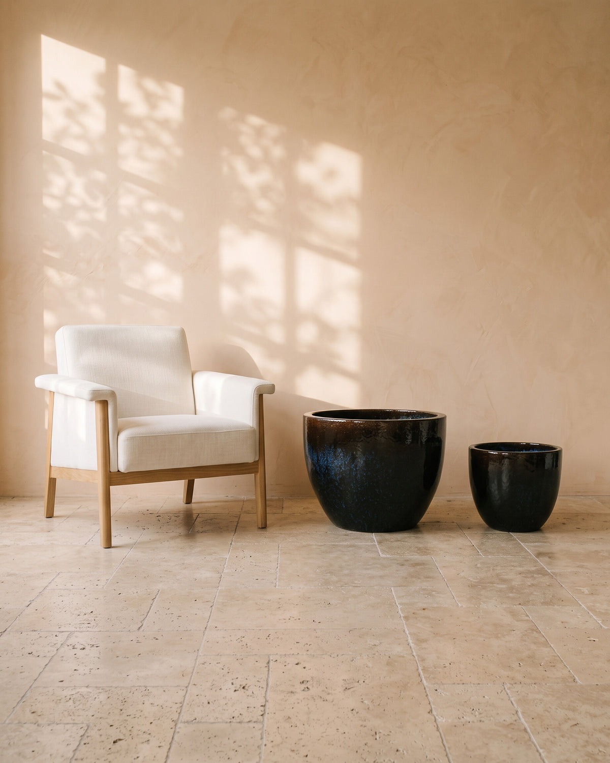 Blue Night Glossy Pot, all sizes, shown beside a linen armchair for scale