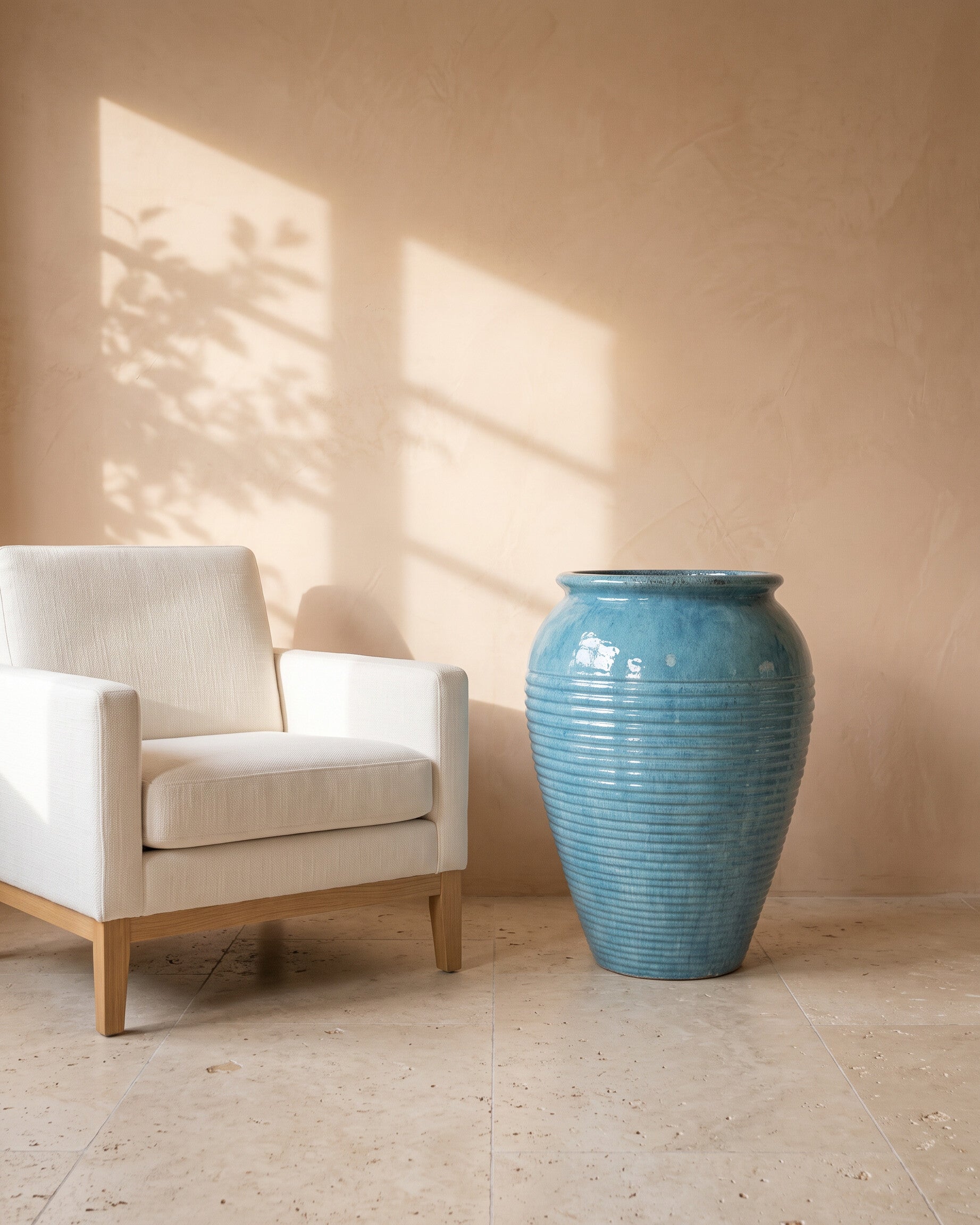 Jade Mist Glossy Pot, shown beside a linen armchair for scale