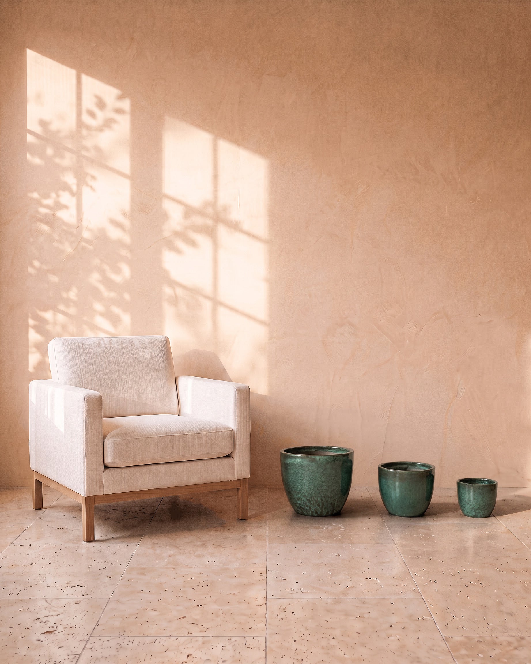 Moss Green Glazy Pot, all sizes, shown on the floor beside a linen armchair for scale