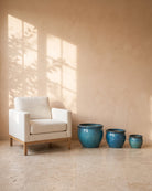 Jade Blue Round Pot, all sizes, shown beside a linen armchair for scale