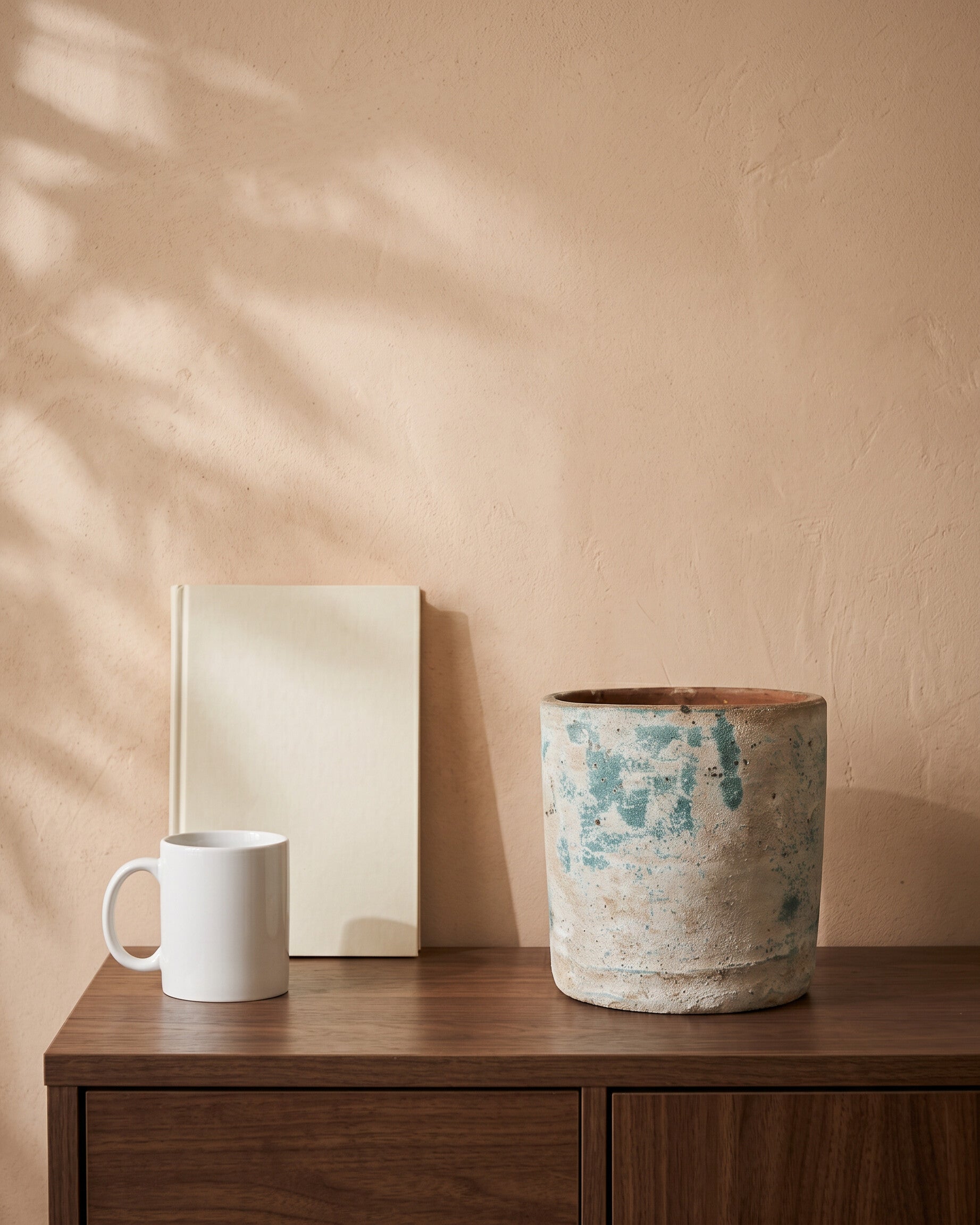 Handcrafted Round Pot, shown on a walnut sideboard next to a coffee mug and a book for scale