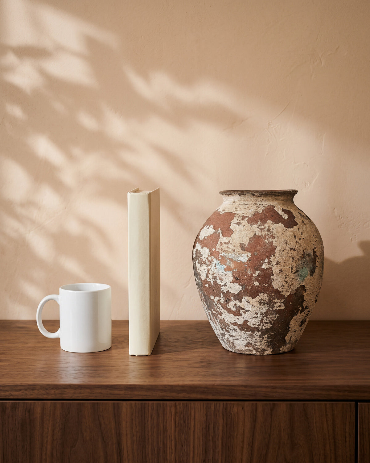 Vintage Mix Vase, shown on a walnut sideboard next to a coffee mug and a book for scale
