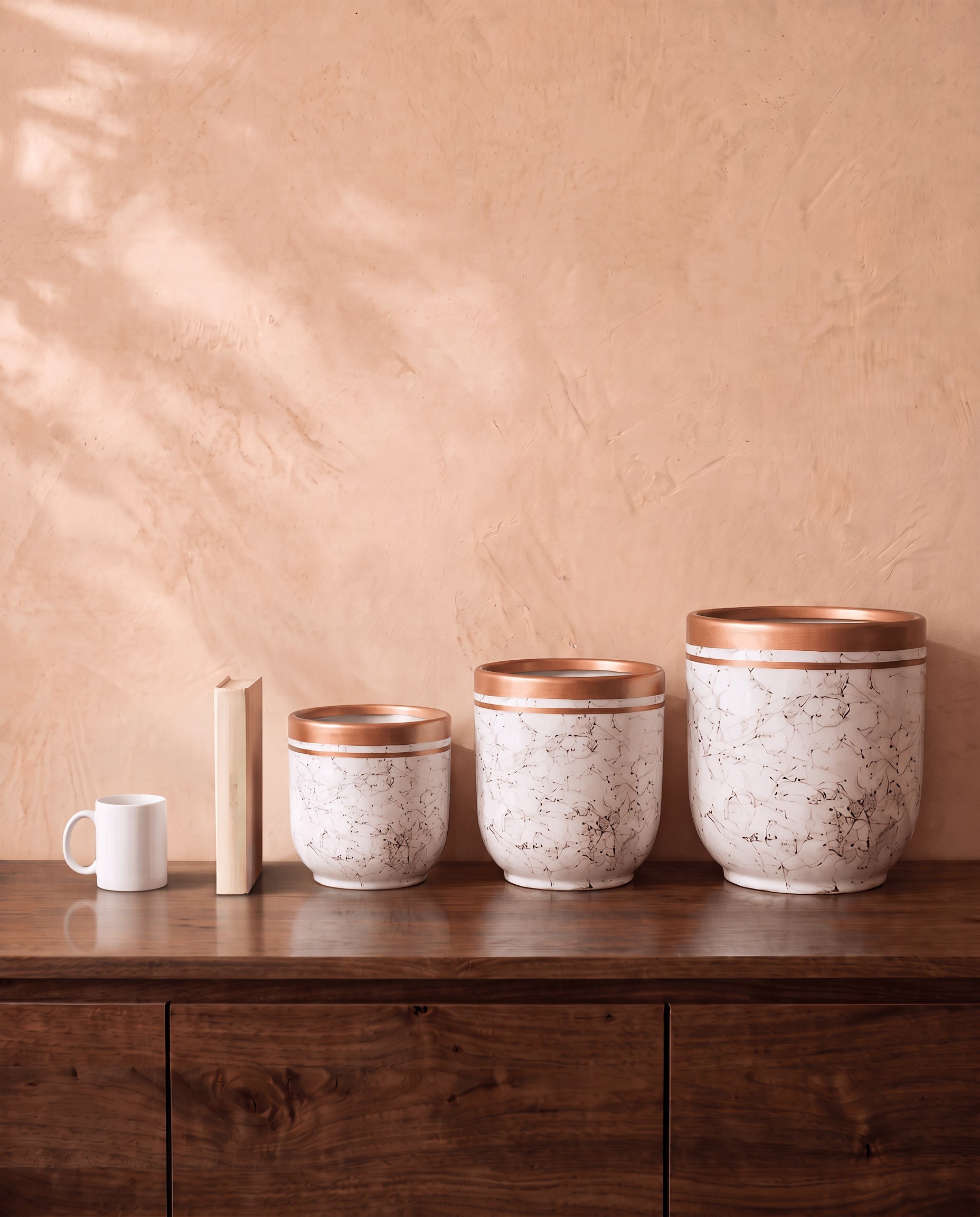 Marble Pot in white, all sizes, shown on a walnut sideboard next to a coffee mug and a book for scale