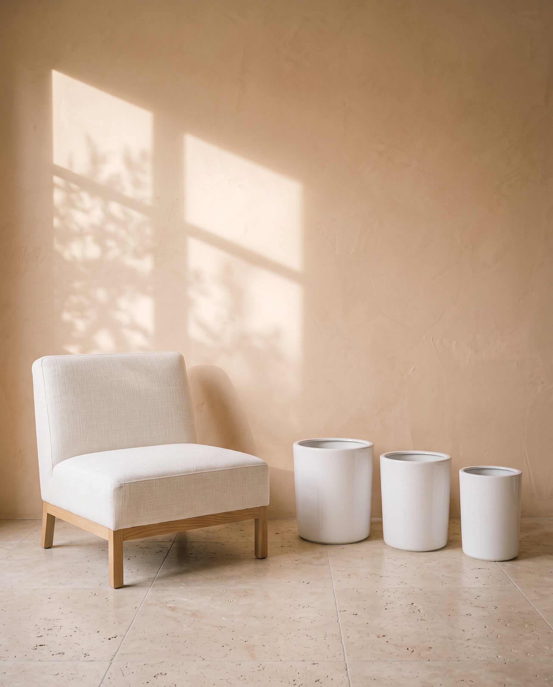 White Cylindrical Pot, all sizes, shown beside a linen armchair for scale