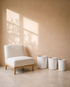 White Cylindrical Pot, all sizes, shown beside a linen armchair for scale