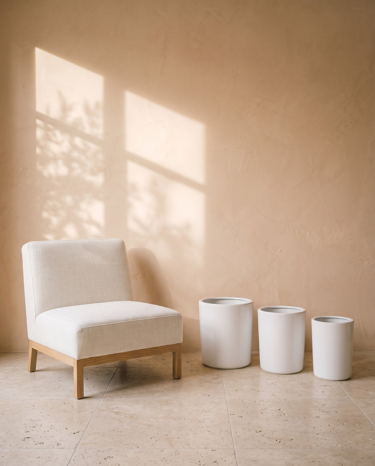 White Cylindrical Pot, all sizes, shown beside a linen armchair for scale