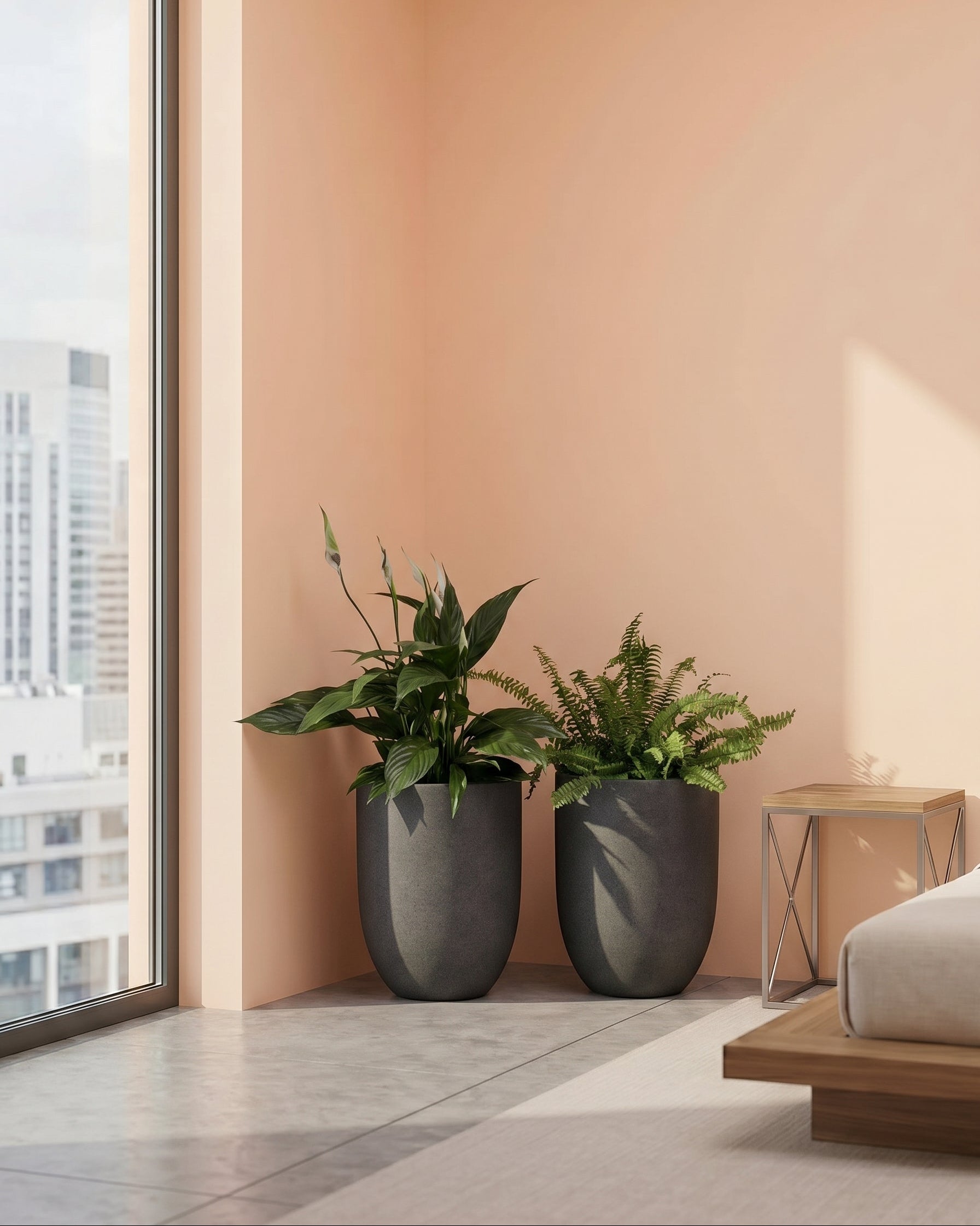 Two potted plants in gray pots on a windowsill with a cityscape view.